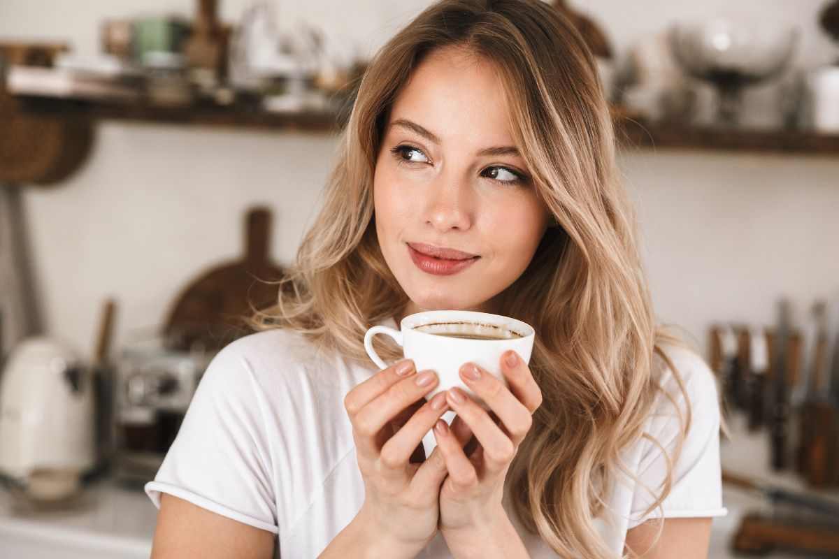 Ragazza beve tazzina di caffè