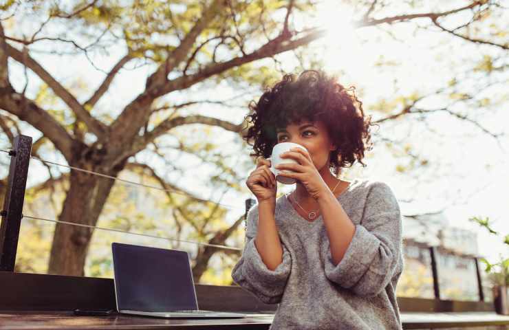 ragazza beve caffè all'aperto